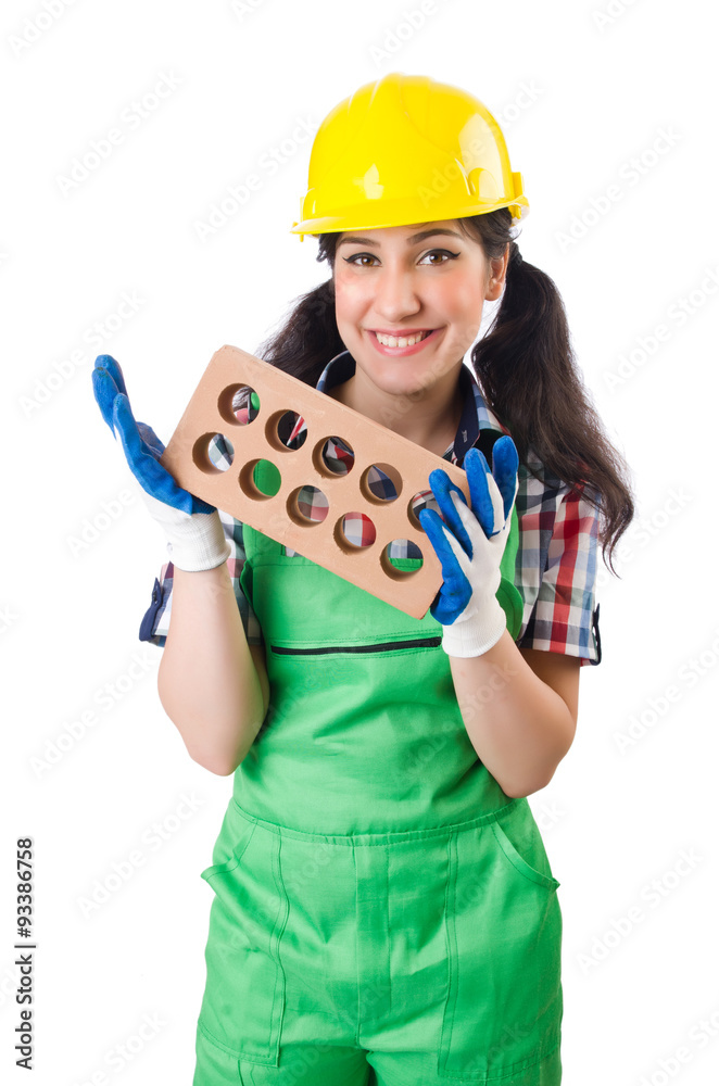 Female workman in green overalls holding brick isolated on white