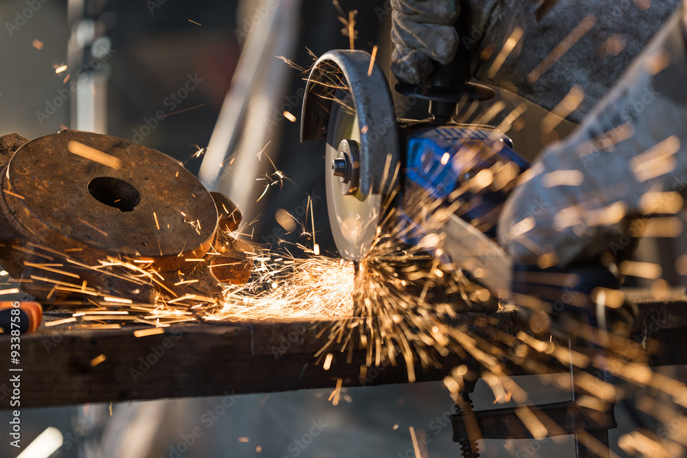 Worker cutting metal with grinder. - obrazy, fototapety, plakaty 
