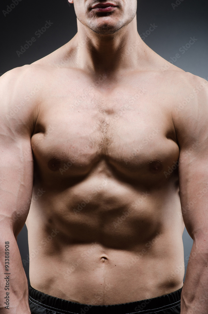 Fototapeta premium Muscular man posing in dark studio