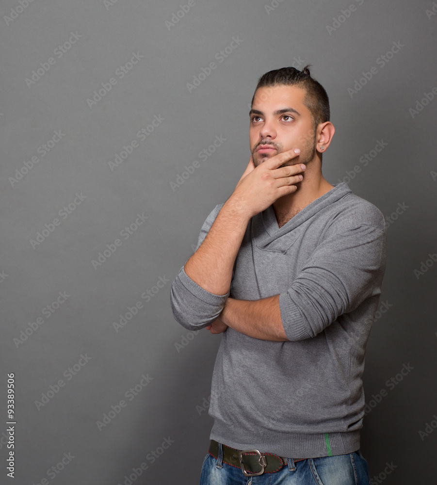 Thoughtful fashionable hipster man in studio