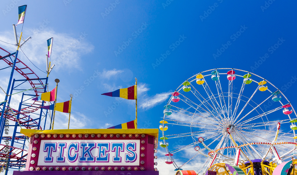 Ticket Booth and Carnival Rides against blue sky - obrazy, fototapety, plakaty 