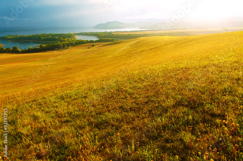 Beautiful landscape  yellow meadow and lake with mountains 