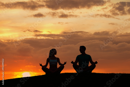 Man and woman meditating in the mountains. 
