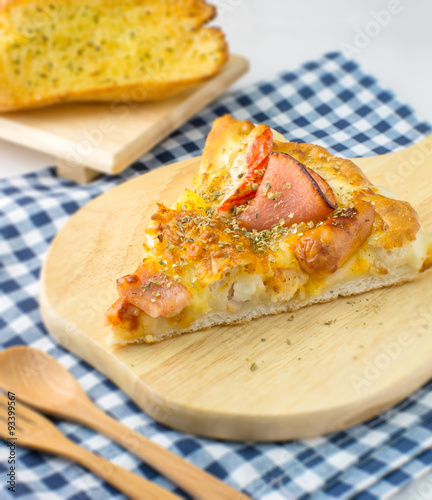 hawaiian pizza with garlic bread on wood table