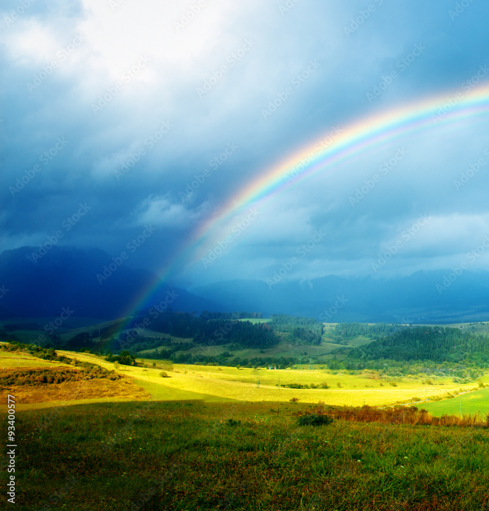 Obraz premium meadow and lake with mountain on background a rainbow 