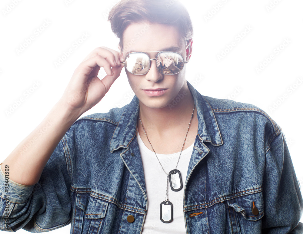 Fashion portrait of the young  man wearing jeans jaket with reflection in glasess