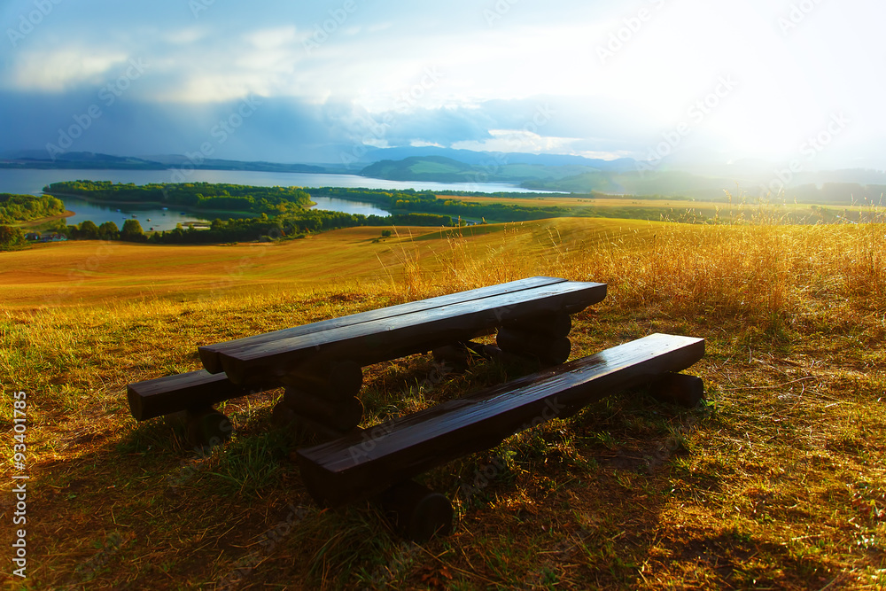 Obraz premium Beautiful landscape. Wooden bench in the meadow, and lake 