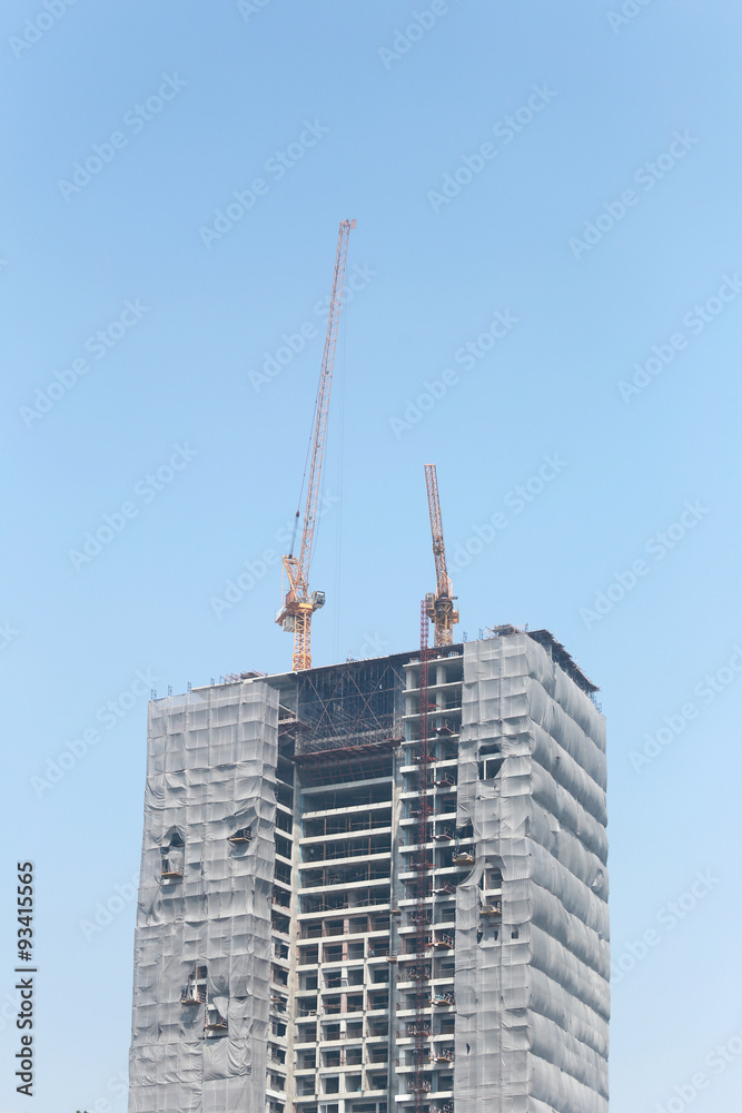 Fototapeta premium Crane working on a building under construction.
