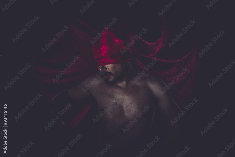 Halloween, naked man on large red cloth over his eyes Halloween, naked man on large red cloth over his eyes