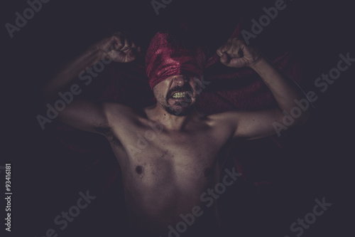 Fototapeta Naklejka Na Ścianę i Meble -  Halloween, naked man on large red cloth over his eyes