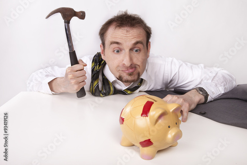 Photography Businessman is trying to break the piggybank with hammer
