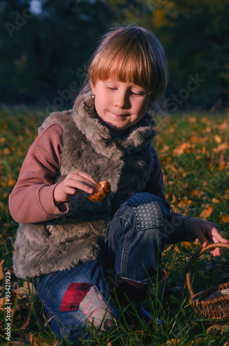 autumn portrait of a little blond girl in fur vess in a park photo