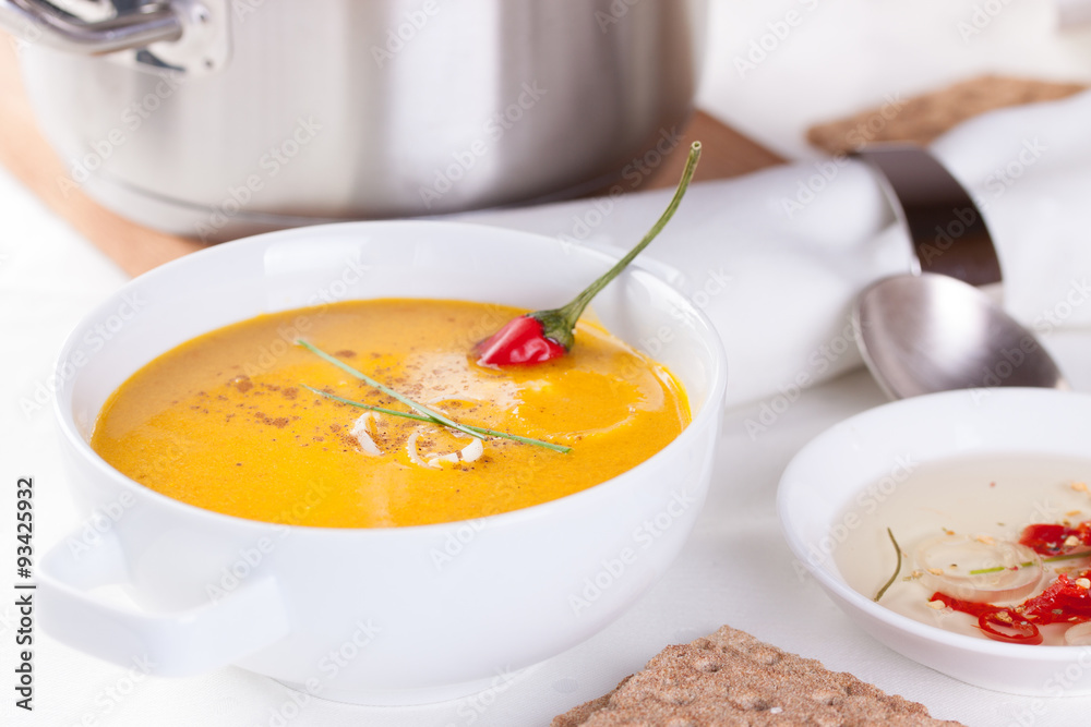 Vegetable soup with pumpkin, carrot, red pepper and cream in white bowl on white background. Vegetable soup with pumpkin, carrot, red pepper and cream in white bowl on white background.