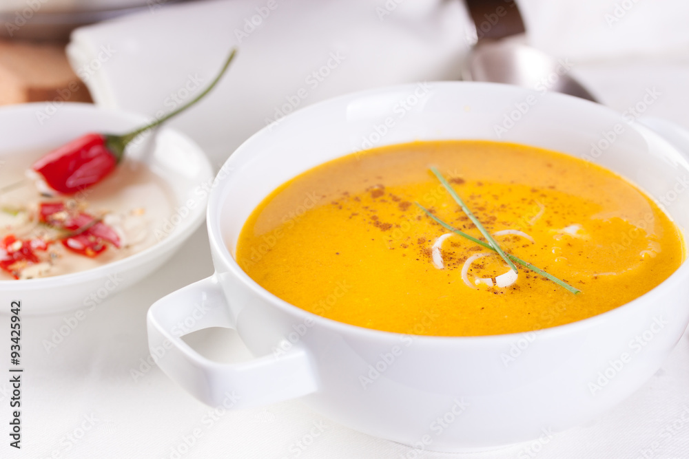 Vegetable soup with pumpkin, carrot, red pepper and cream in white bowl on white background. Vegetable soup with pumpkin, carrot, red pepper and cream in white bowl on white background.