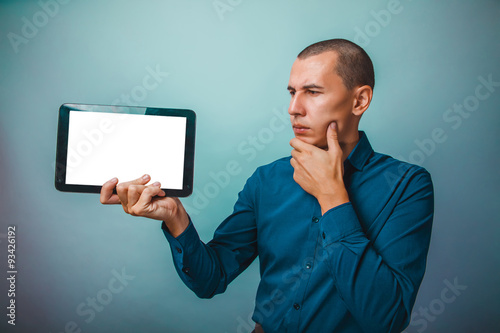 a man of European appearance thirty years, holding a tablet frow photo