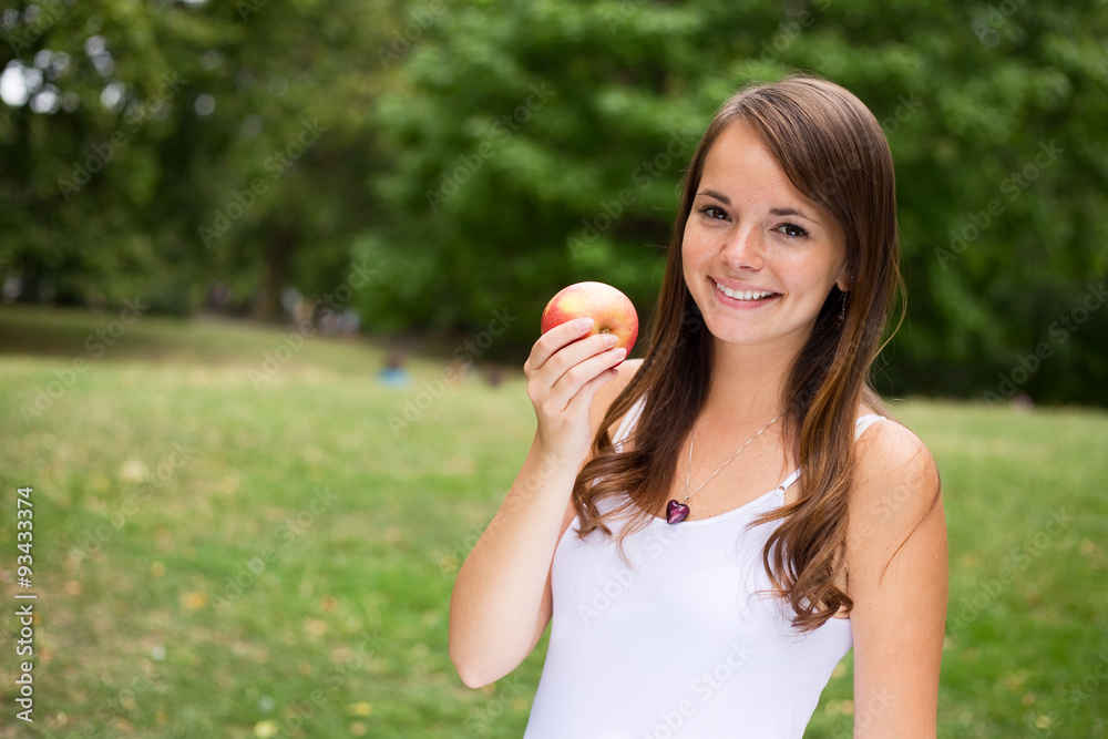 young woman smiling holding an apple young woman smiling holding an apple