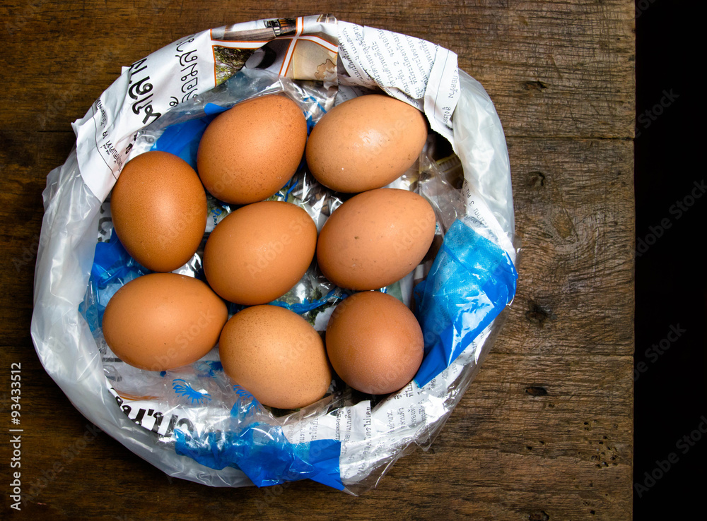 eggs in plastic bad on wooden table eggs in plastic bad on wooden table