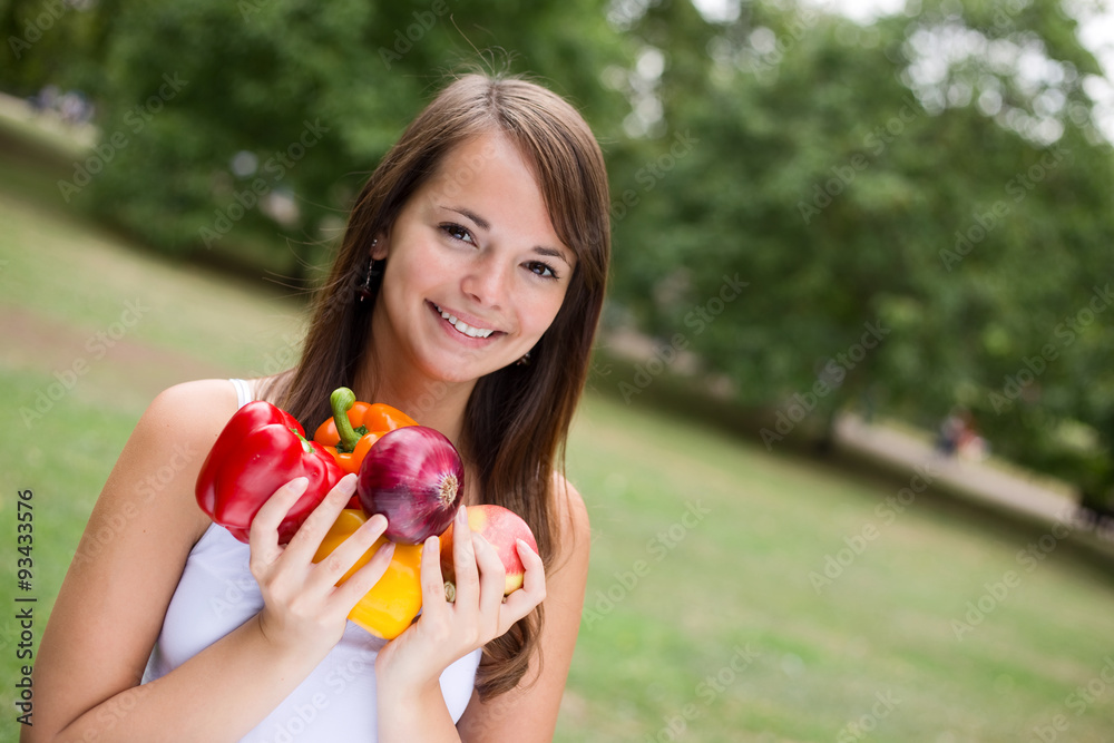 young woman smiling holding a selection of fruit and vegetables young woman smiling holding a selection of fruit and vegetables