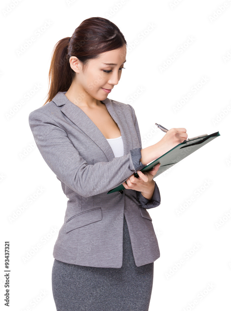 Businesswoman take note on file board Businesswoman take note on file board