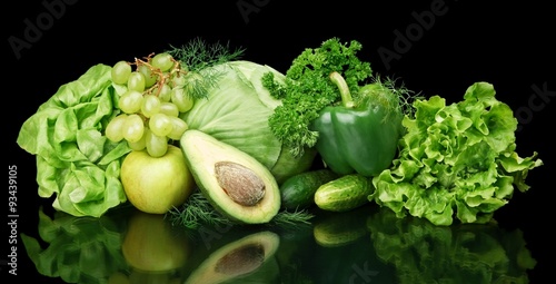 Collection of green vegetables and fruits on black