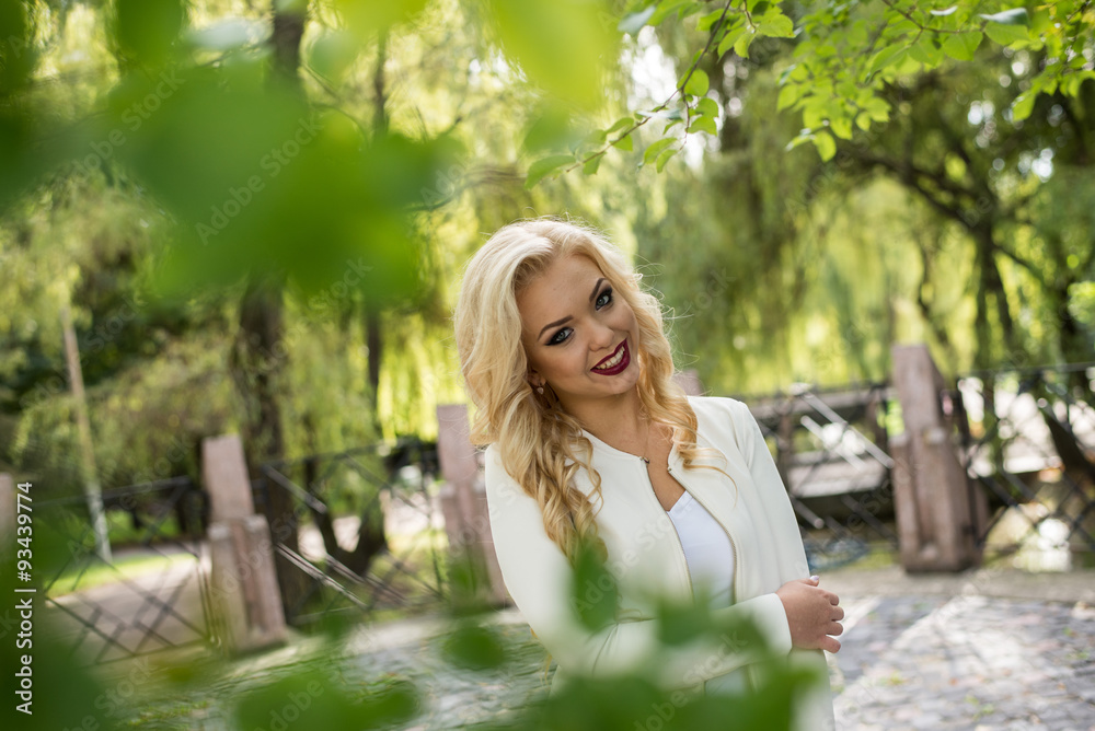 Naklejka premium Portrait beautiful smiling young woman in green summer city park