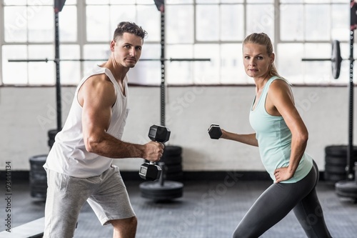  Couple exercising with dumbbells in gym