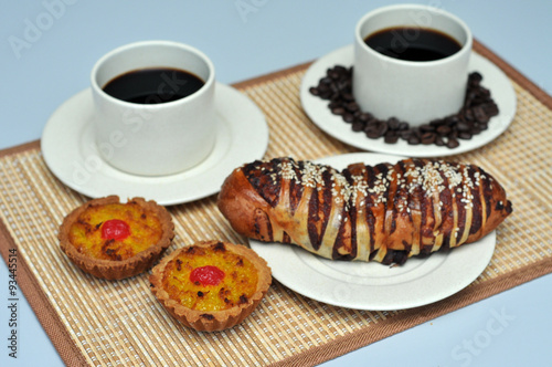 red bean bread and coconut tart on bamboo mat with hot coffee