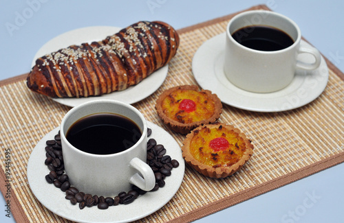 hot coffee with coconut tart and red bean bread on bamboo mat