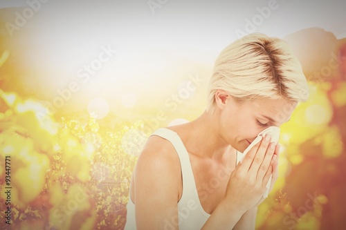 Composite image of sick woman blowing her nose