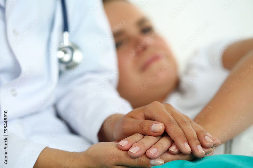 Friendly female doctor hands holding patient hand Friendly female doctor hands holding patient hand