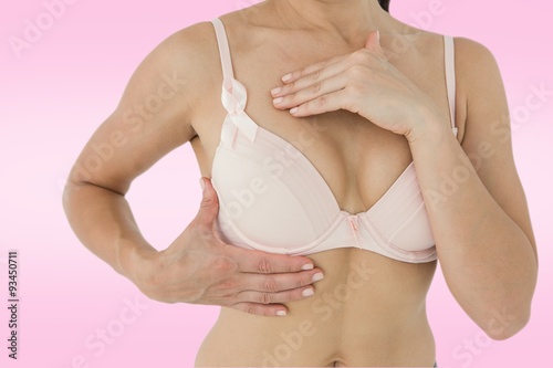 Composite image of woman in bra with breast cancer awareness