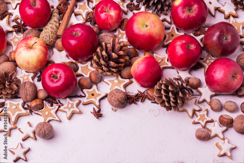 Christmas background. Gingerbread cookies, apples, spices and nu