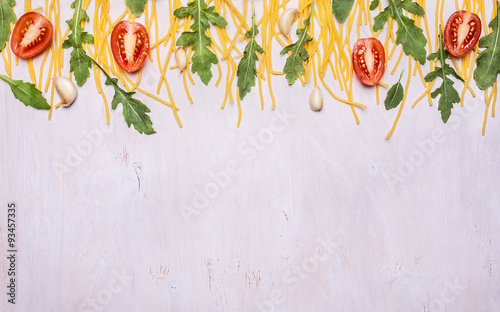 border raw pasta arugula cherry tomatoes on wooden rustic background close up top view banner for website  space for text