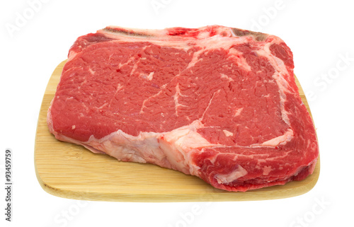 Bone in rib eye steak on wood cutting board