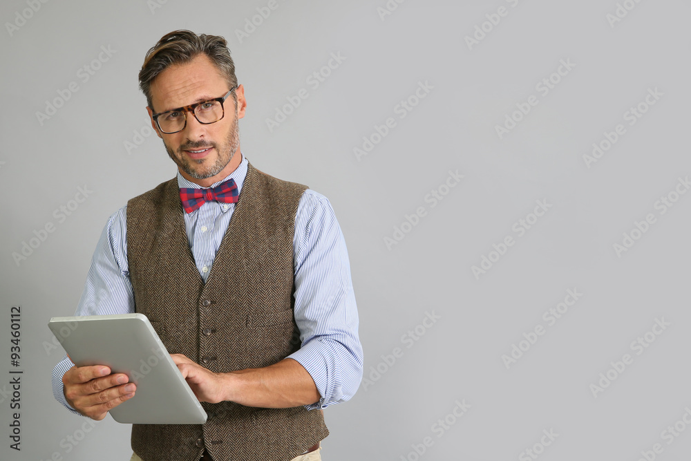 Stylish guy using digital tablet on grey background Stylish guy using digital tablet on grey background