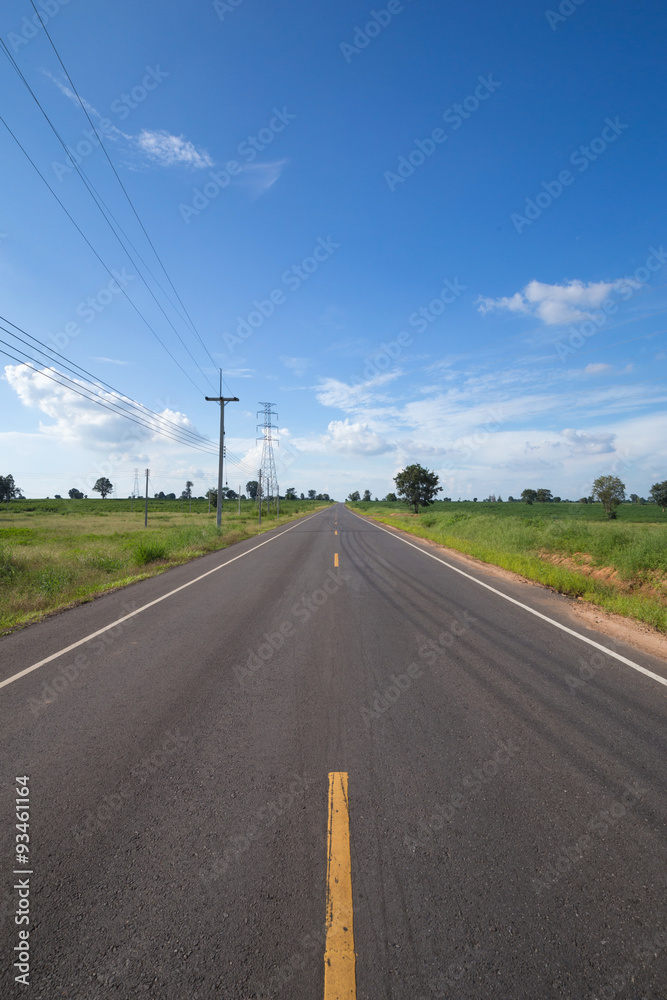 asphalt road through the green field