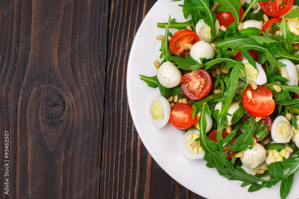 Salad with arugula on a wooden background Salad with arugula on a wooden background
