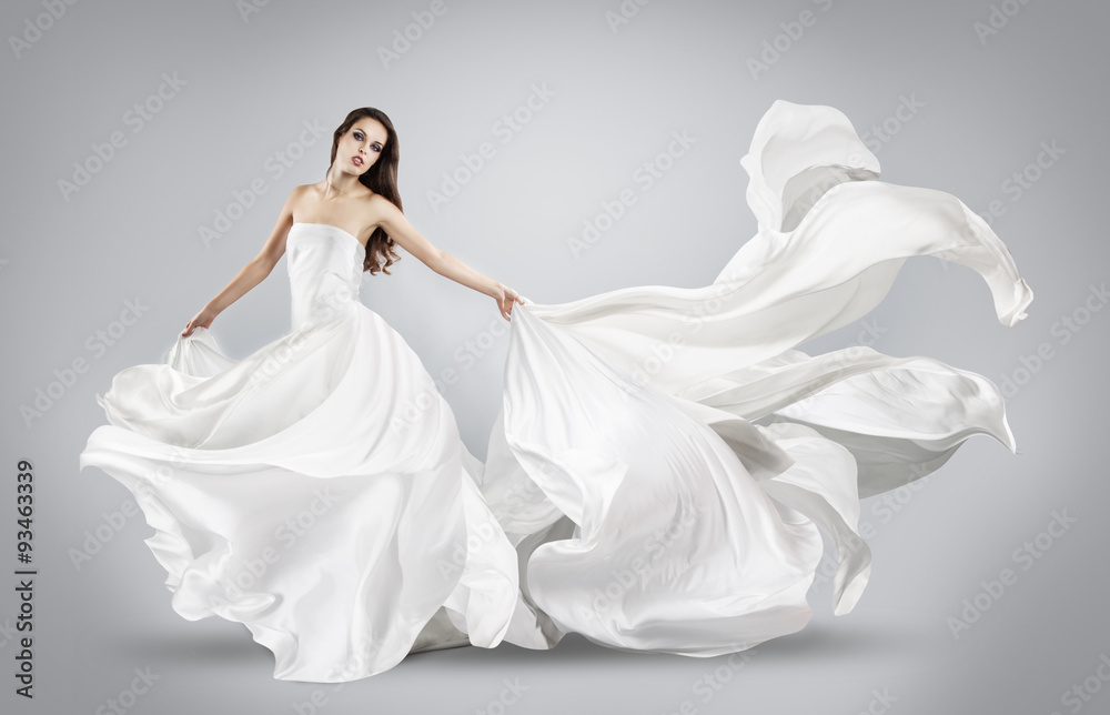 Fototapeta premium piękna młoda dziewczyna w latającej białej sukni. Lejąca tkanina