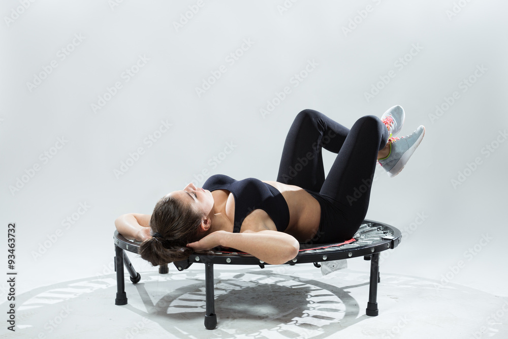 Young fitness-girl make exercises on rebounder Young fitness-girl make exercises on rebounder