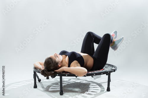 Young fitness-girl make exercises on rebounder photo