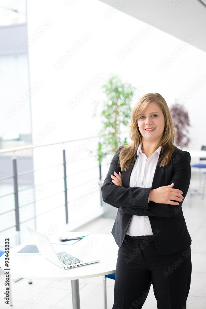 Businesswoman working & sitting at her desk in an office Businesswoman working & sitting at her desk in an office