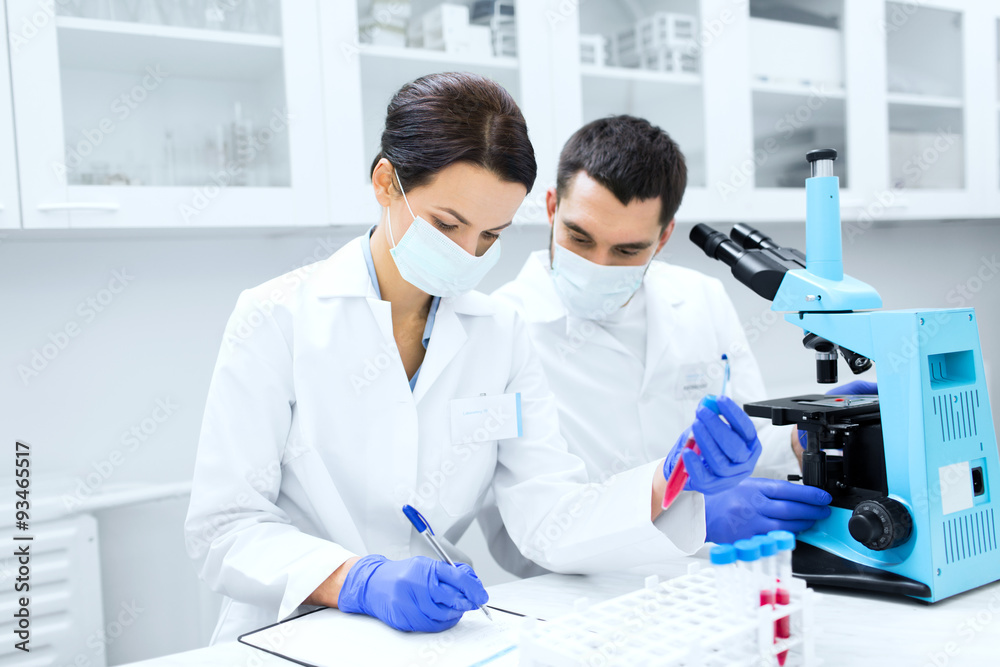 scientists with clipboard and microscope in lab scientists with clipboard and microscope in lab