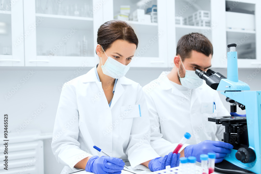 scientists with clipboard and microscope in lab scientists with clipboard and microscope in lab