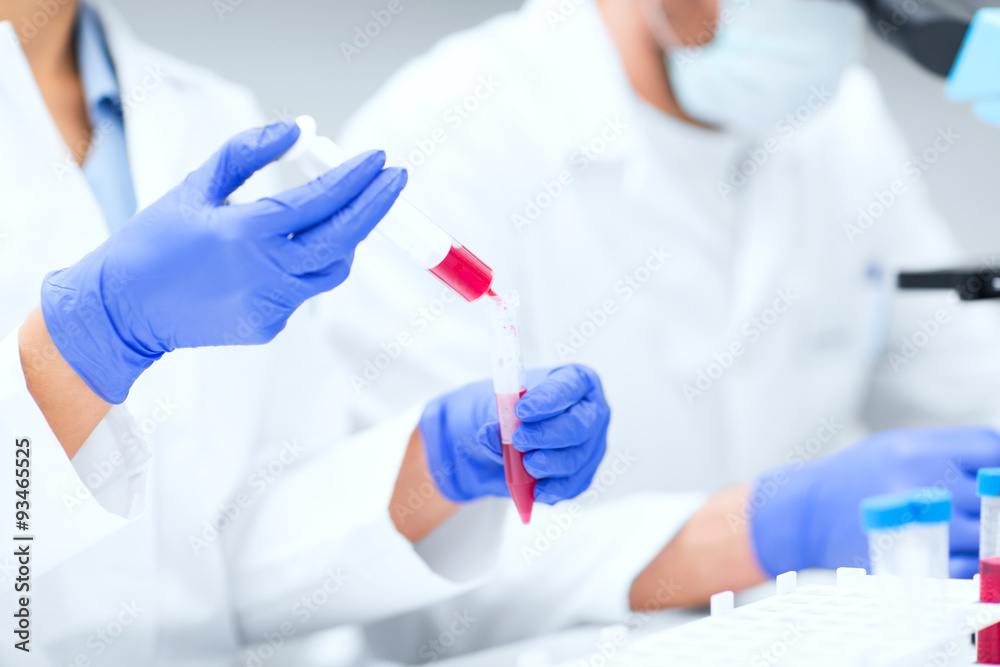 close up of scientists hands with test tube in lab