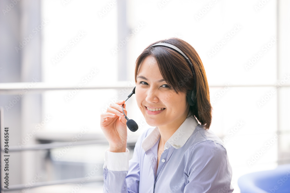 Asian Business woman talking using her headset in the office Asian Business woman talking using her headset in the office