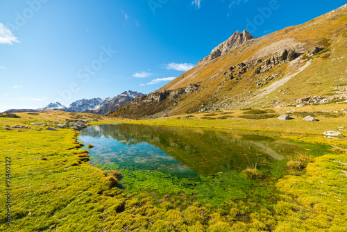 High altitude green alpine lake in autumn season