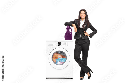 Businesswoman standing by a washing machine