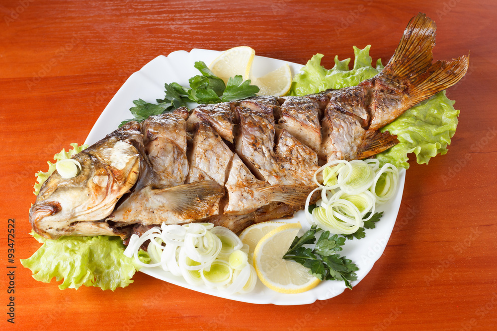Roasted carp fish with vegetables entirely. Traditional Christmas meal. Roasted carp fish with vegetables entirely. Traditional Christmas meal.