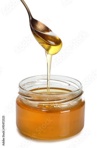 Glass jar with honey on white background