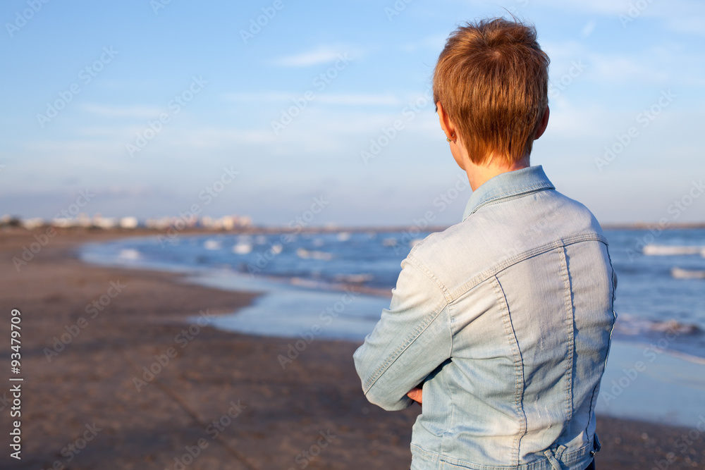 Mujer en la playa esperando y mirando al horizonte Mujer en la playa esperando y mirando al horizonte